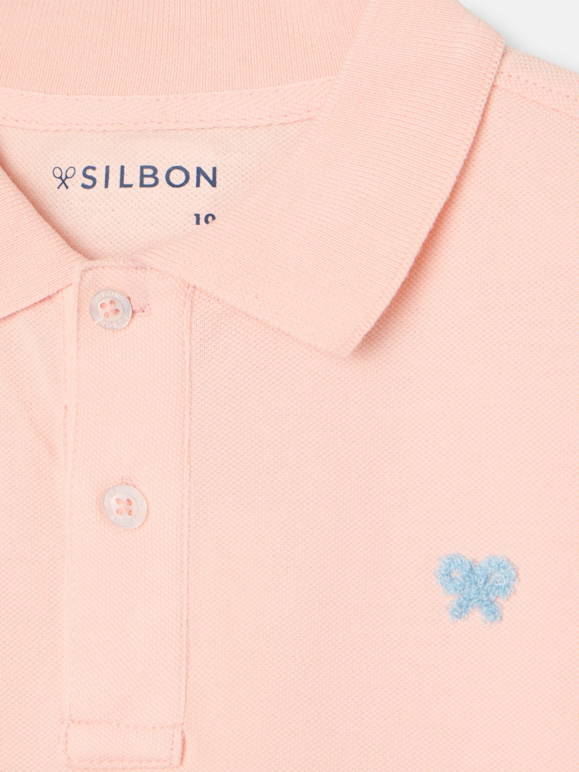 Polo enfant uni logo bouclé corail