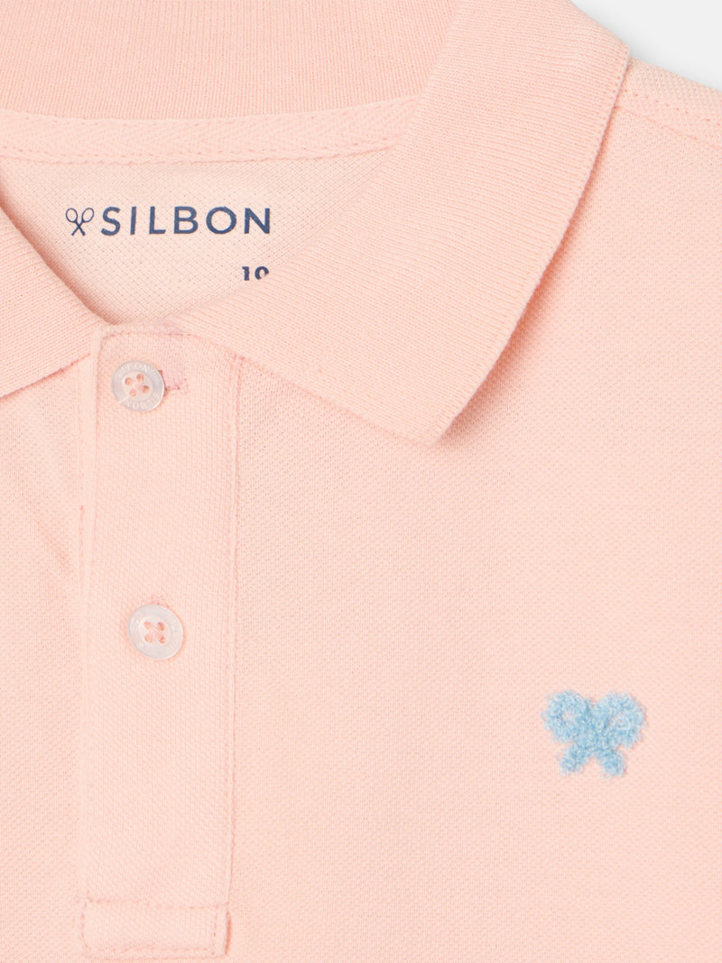 Polo enfant uni logo bouclé corail